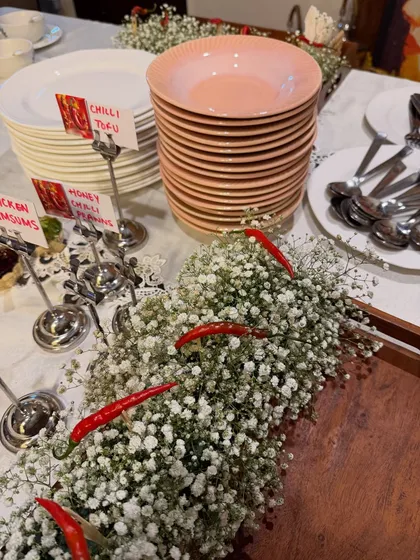 A section of our Asian buffet, featuring Chilli Tofu and Honey Chilli Potatoes. The table is decorated with baby's breath and red chillies, showing how we incorporate small, thoughtful details into our setups.