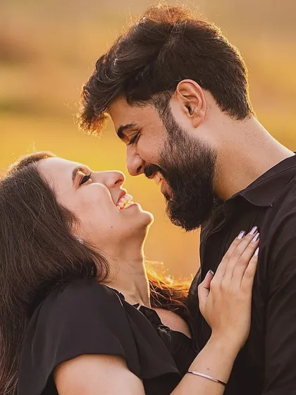 Capturing the golden hour glow. This intimate, sun-kissed portrait of a couple sharing a laugh showcases the warm, natural, and candid style we love for pre-wedding photography.