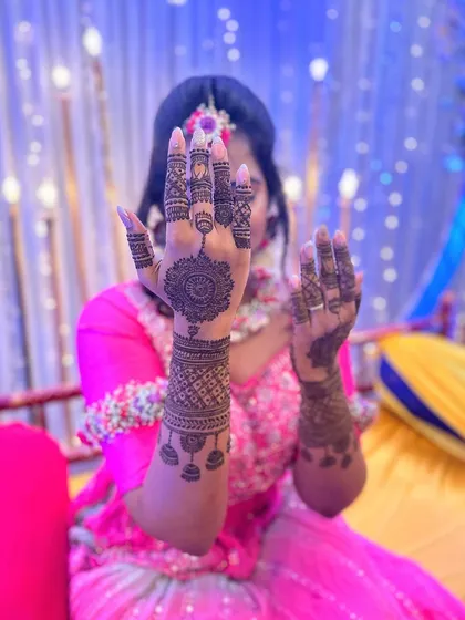 A playful pose showing off the modern mandala and cuff design. This style is perfect for someone who wants festive but not fully traditional mehndi.