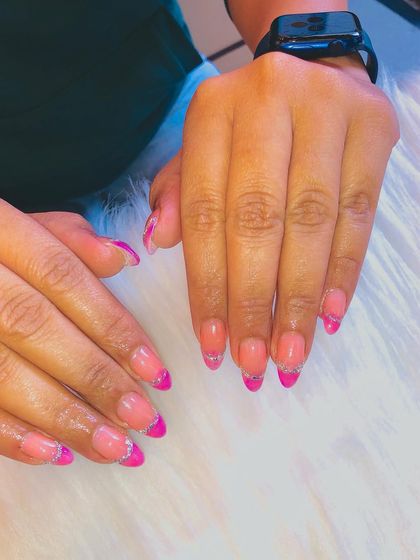 A bright pink ombre nail with a silver glitter French line, creating a fun and glamorous look.