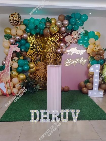 A modern jungle theme birthday with a large giraffe cutout, a gold sequin wall, and a "Wild One" vibe.