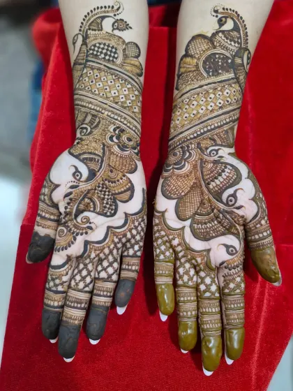 A graceful design featuring flowing peacock motifs that curve elegantly from the wrist up the arm.
