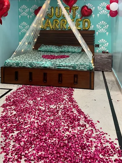 I offer romantic room decoration for the wedding night. This 'Just Married' setup includes a pathway of rose petals, a bed canopy with fairy lights, and foil balloons to create a special and intimate atmosphere.