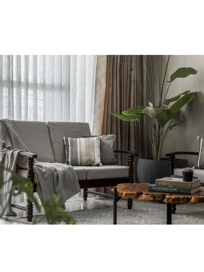 This apartment living room uses a warm, neutral palette with comfortable, classic furniture. A live-edge wooden coffee table adds a touch of organic texture to the space.
