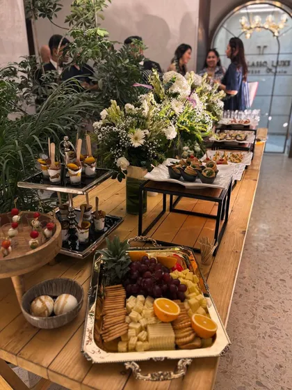 A view of a lavish spread designed for a sophisticated gathering. The table showcases a variety of offerings, from a classic charcuterie board to individual dessert cups and savory canapés, demonstrating the breadth of my gourmet catering services.