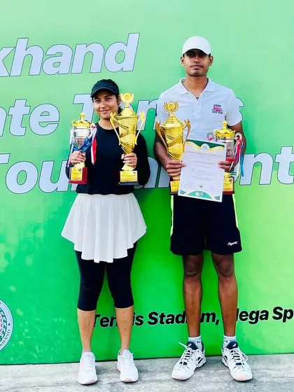 Ayesha and her mixed doubles partner with their trophies. We train players for both singles and doubles, emphasizing different strategies for each format.