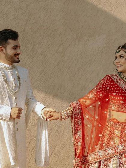 A candid shot of the couple holding hands and sharing a look, bathed in the warm afternoon sun.