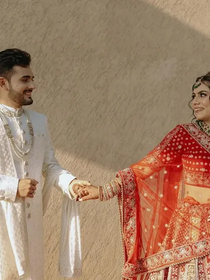 A candid shot of the couple holding hands and sharing a look, bathed in the warm afternoon sun.