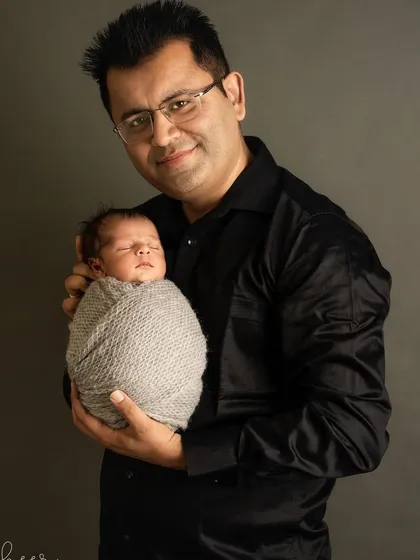 A father's strong and gentle hold, cradling his tiny, sleeping son. This classic father and baby portrait is a powerful symbol of protection and love.