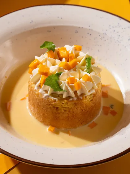 A mango tres leches dessert, styled to look light and refreshing. Perfect for a seasonal menu.