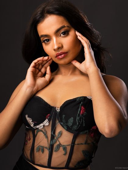 A beauty-focused shot from the same series, with the model's hands framing her face.