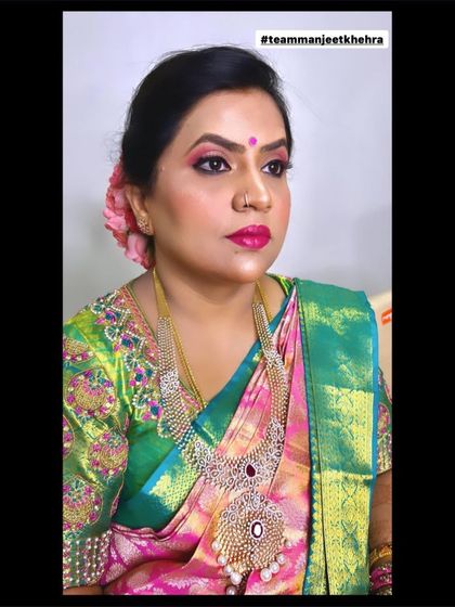 A glamorous reception look with bold pink lips and shimmery eyes, complemented by a beautiful silk saree and diamond jewellery.