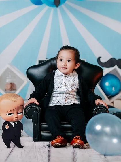 One of the greatest gifts I’ve ever gotten is my child. A little boss baby sits in his big chair in our fun, cartoon-themed studio.