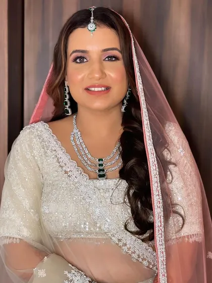 Bride Annie looking stunning for her wedding. The combination of a white lehenga with a pop of emerald in the jewelry is so chic.