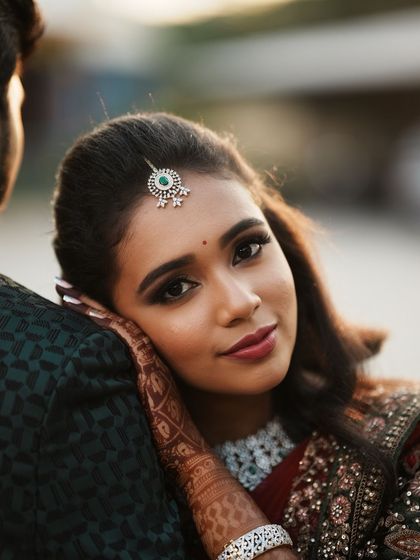 A close-up of Dr. Saruna's reception makeup. The look features a defined smoky eye and a beautiful lip colour that enhances her smile.