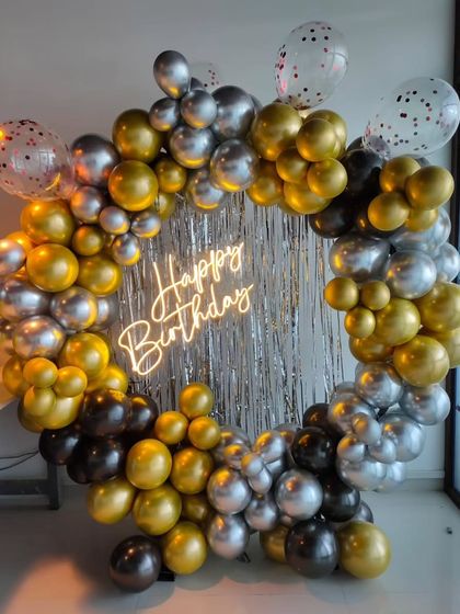 A classic birthday ring in gold, silver, and black, with a silver shimmer backdrop and a neon sign.