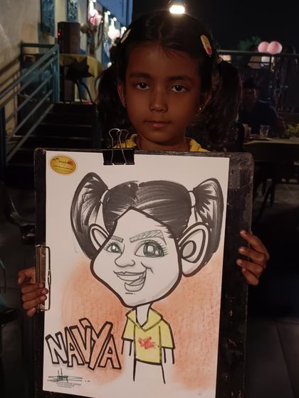 A little girl named Navya with her pigtails, captured perfectly in her caricature.