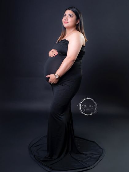 A classic solo maternity portrait against a solid black background. This timeless style puts all the focus on the mother-to-be's beautiful silhouette.