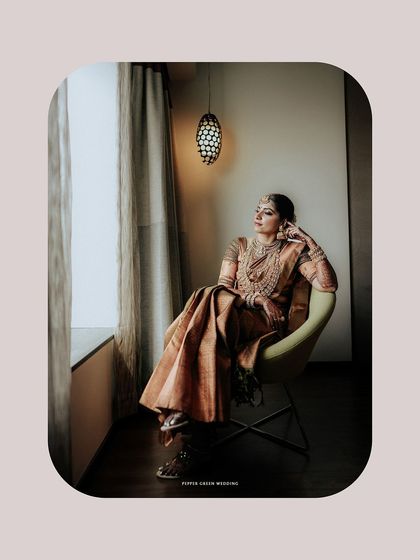 A beautifully framed portrait of the bride, Sradha. This artistic shot emphasizes her elegance and the quiet moments of reflection on her wedding day.
