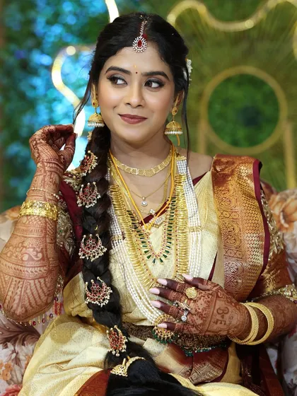 This portrait highlights the traditional South Indian bridal hairstyle, a long braid decorated with beautiful hair accessories.