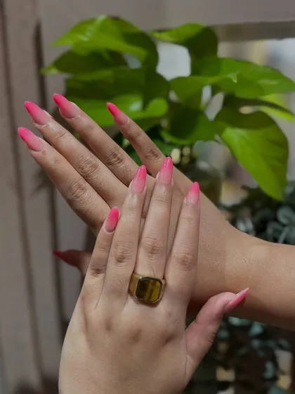 A beautiful and vibrant pink ombré on long, stiletto nails. It's a fun and feminine look that makes a statement.