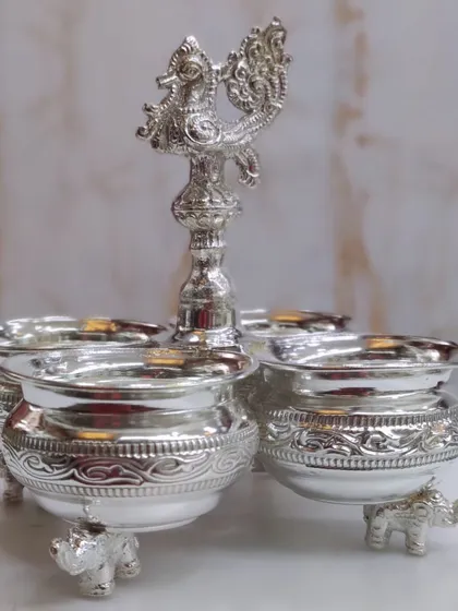 My German silver Panchwala set, with its elegant peacock handle and elephant-leg bowls, is a very popular choice. It's a functional and ornate piece for holding haldi, kumkum, and other sacred offerings.
