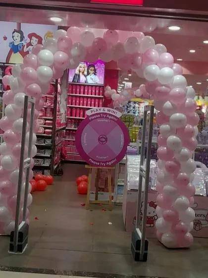 A beautiful pink and white balloon arch at a mall entrance, perfect for store openings, sales events, or themed promotions.