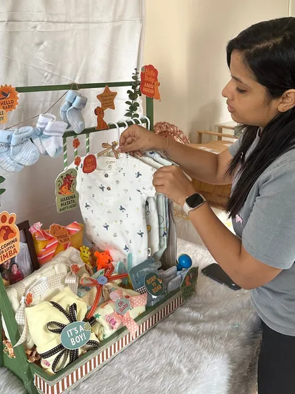 Here I am, in my element, arranging a jungle-themed baby wardrobe hamper. I love getting every little detail just right, from hanging the onesies to placing the themed cutouts.