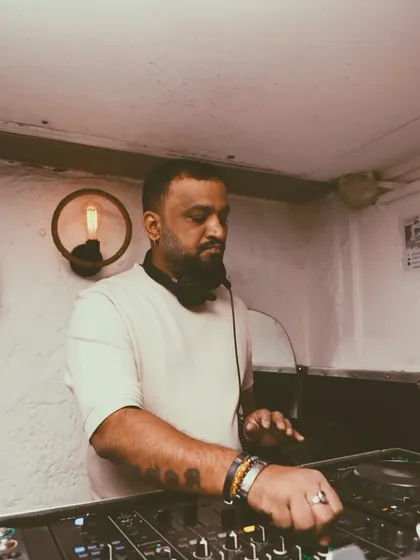 A portrait-style shot of me at the console, bathed in the warm light of the club. This is me in my element, doing what I love.