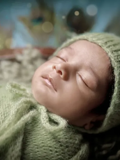 A detailed close-up of the baby's serene face during our Little Krishna photoshoot. We ensure your baby is always comfortable and peaceful, even in our most elaborate setups.
