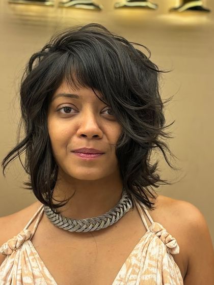 A frontal view of a client with her new short, layered haircut. The style is modern, flattering, and full of personality.