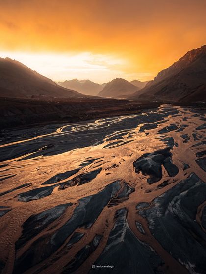 The Spiti River at sunset, with its braided channels glowing like molten gold. This is an aerial photograph I took to capture the abstract, painterly quality of the landscape from above.
