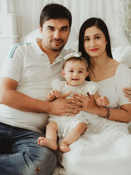 A classic family portrait with a relaxed and happy feel. The coordinated white and denim outfits are a perfect choice for a timeless look.