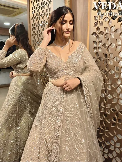 A close-up showcasing the delicate jewelry and the intricate beadwork on the blouse of this beige lehenga.