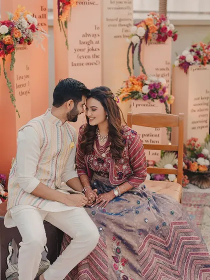 An intimate and romantic shot of the couple, surrounded by the warm colors and soft textures of their Haldi decor.