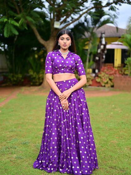 A full-length shot in an outdoor setting. The makeup is fresh and vibrant, matching the playful energy of the outfit.