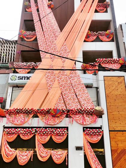 A unique printed fabric draping in peach tones, accented with floral arrangements for a soft and romantic wedding home look.