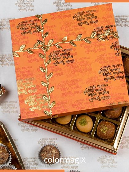 Our Ganesh Chaturthi sweet box is a gift of devotion. The orange box is adorned with Sanskrit shlokas and a golden leaf motif, filled with an assortment of delicious laddus and pedas.