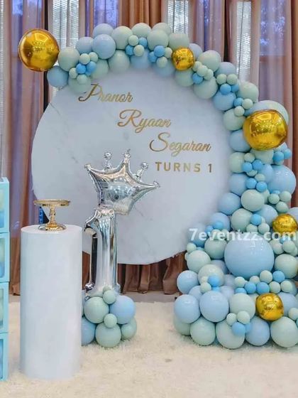 A "Prince" themed first birthday in pastel blue and gold. This setup includes a custom backdrop, a crown foil balloon, a "1" foil balloon, and "BABY" blocks.