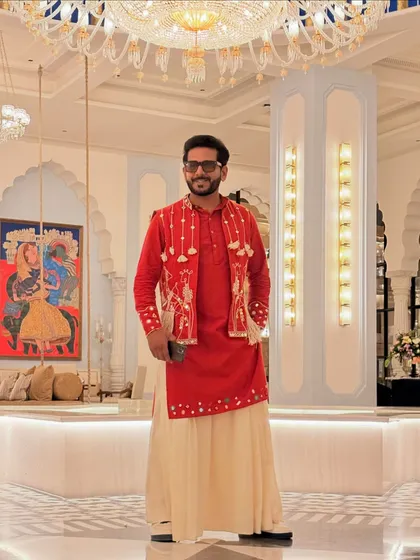All set for a 'Banjara' themed event in this striking red and cream outfit. The layered look with the embroidered jacket and flowing pants perfectly captures the nomadic, free-spirited vibe.