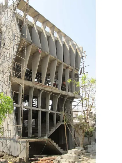 The SPKCO office building under construction. This photo reveals the raw concrete structure of the warped facade, showing the complexity of the engineering required to realize the design.