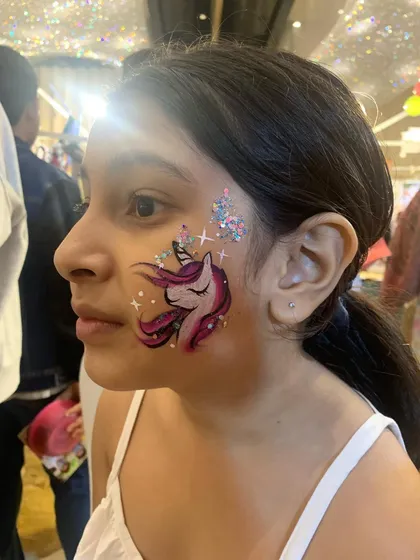 A close-up of our signature unicorn face paint, complete with magical glitter and sparkling stars. This is one of our most requested designs for birthday parties and brings so much joy to the little ones.