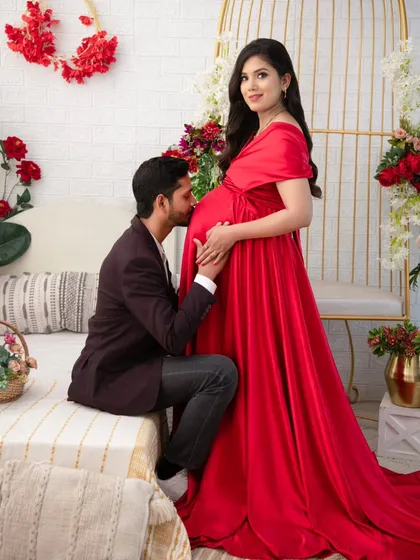 A classic and powerful portrait of love and anticipation. The rich red satin gown against the floral backdrop creates a feeling of romance and celebration. A father's gentle kiss on the belly is a gesture of protection and deep affection that I am honored to capture.