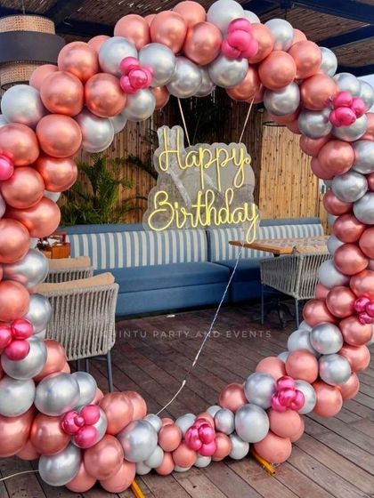 A stylish balloon ring decoration using chrome rose gold and silver balloons, accented with small pink clusters. This setup is perfect for a chic birthday celebration at a restaurant or cafe.