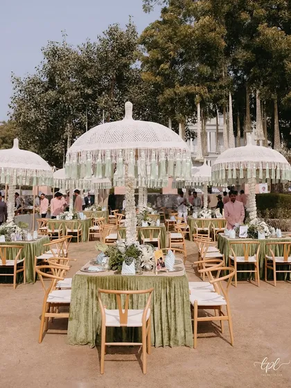 An elegant outdoor luncheon setup with sage green linens and custom fringed umbrellas. This demonstrates our ability to create chic, comfortable daytime events that are both beautiful and practical.