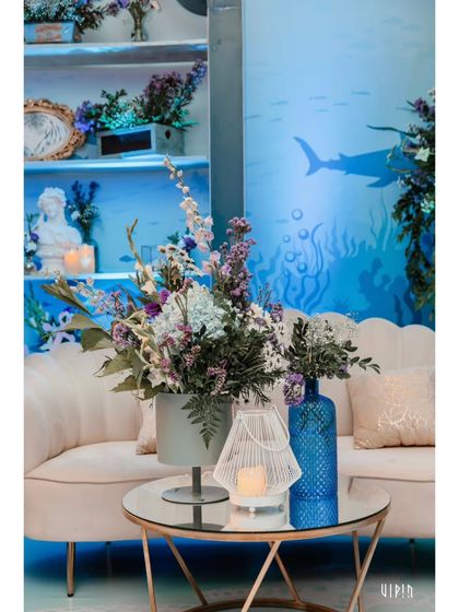 A cozy corner in the lounge area, with an ocean-themed backdrop and beautiful floral arrangements. I design these spaces to be both comfortable and visually stunning.