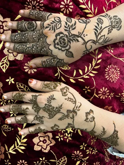 This image shows two different styles side-by-side. One hand has a dense, traditional pattern while the other features a more modern, spaced-out floral vine, showing the versatility of my henna.