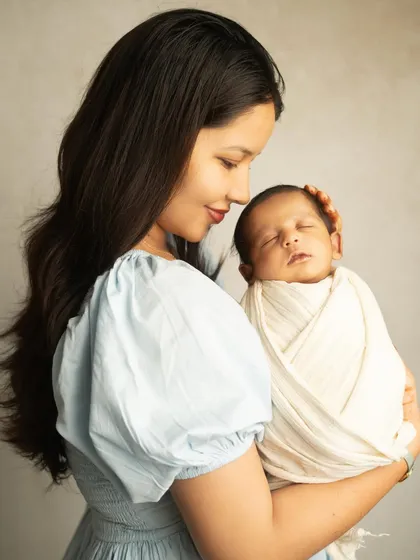 A mother's embrace is a baby's first home. This tender moment captures the quiet love and security a newborn feels in their mother's arms.