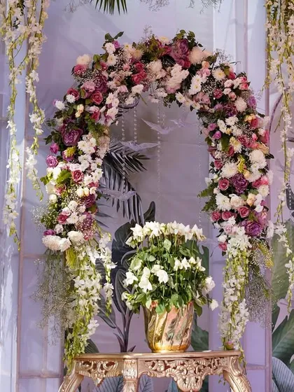 A stunning floral arch for a destination wedding in Jaipur. The arch is covered in a beautiful gradient of pink, purple, and white flowers, creating a breathtaking frame for a ceremony or photo op.