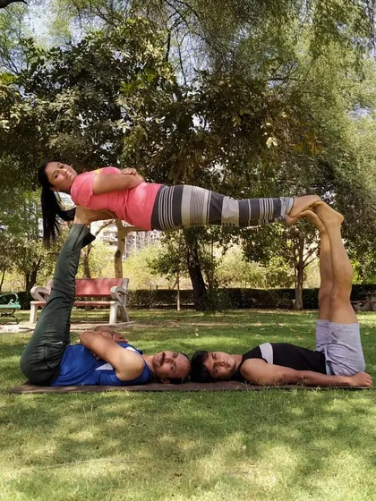 A fun, multi person acro yoga pose that creates a human table. This kind of partner yoga is a fantastic way to build core strength and stability while having a great time with friends.